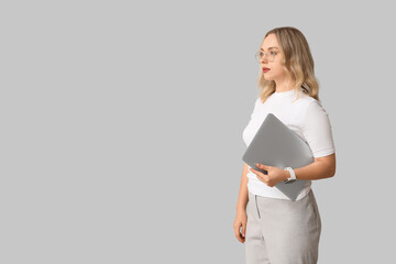 Wall Mural - pretty young woman with modern laptop on grey background