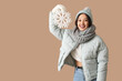 © Pixel-Shot - Beautiful young Asian woman in warm scarf with snowflake on brown background