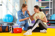 © Pixel-Shot - Female doctor with inhaler giving young woman first aid in gym