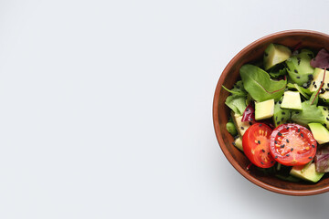 Wall Mural - Bowl of tasty avocado salad with cherry tomato and sesame seeds on grey background