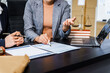 © Phushutter - Two female lawyers in business suits meet at wooden desk, shaking hands over contract paper. wooden gavel and scales justice as discuss legal compliance, corporate law, dispute resolution.