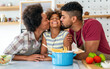 © NDABCREATIVITY - Happy african american family preparing healthy food in kitchen, having fun together on weekend