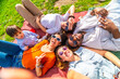 © unai - Happy friends and baby taking selfie lying on blanket in park