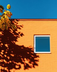 Poster - Minimalist Urban Architecture Golden Brick Facade with Dynamic Tree Shadow Play - Contemporary Design Aesthetic Capturing Architectural Geometry and Natural Light Interaction