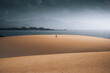 © Travel 'n' Lifestyle - View of serene sand dunes and vast ocean under a cloudy sky, Playa de la Pared, Fuerteventura, Spain.