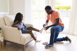 © Wavebreak Media - African American father helping daughter put on socks at home, sharing tender moment