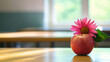 © Erika - un salon de clases con una mesa o escritorio con una manzana roja con una flor para regalar en el dia del maestro con espacio de copia para tarjeta de felicitacion