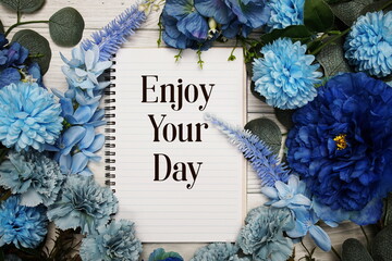 Wall Mural - enjoy your day text with blue flowers bouquet decoration on wooden background