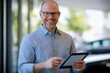 © Ana - Professional photo of a smiling car technician with a modern touch tablet in hand, standing confidently in front of a clean, well-lit backdrop