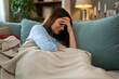© Dexon Dee - Portrait of pensive depressed young woman sitting on couch at home