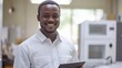 © WS Studio 1985 - Smiling African Engineer Holding Tablet in Modern Office Setting
