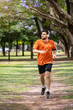 © Javier - Hombre corriendo en un parque urbano en un hermoso día soleado. Hombre trotando mientras escucha música