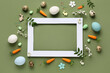 © Pixel-Shot - Frame made of blank photo frame, Easter eggs and flowers on green background