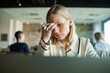 © Marko Geber - Stressed businesswoman working on laptop in modern office