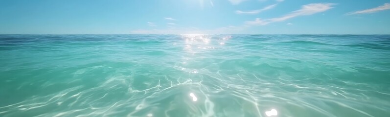 Wall Mural - serene ocean view with clear turquoise water and bright sunlight reflecting on the surface.