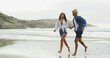 © peopleimages.com - Couple, beach and holding hands with love on vacation for honeymoon, holiday or bonding outdoor in nature. Happy woman, man and run by sea for fun, romantic date and playful with trust in commitment