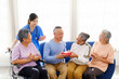 © artitwpd - Happy Asian senior group with caregiver sharing a gift in a nursing home, symbolizing love, companionship, and elderly care support. Perfect for concepts of aging, community, and assisted living.