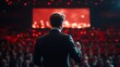 © Pattanan - Speaker on Stage with Audience in Background, Presentation Setting with Dramatic Lighting and Engaged Viewers