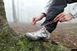 © Antonioguillem - Trekker tying shoelaces of boots in nature