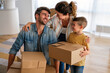 © NDABCREATIVITY - Happy family with child moving with boxes in a new apartment house. Mortgage, real estate investment
