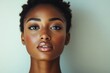 © Basileus - Beautiful dark skinned woman with glossy lips stares intently forward