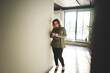 © Flamingo Images - Smiling businesswoman standing in a hallway reading a text message