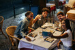 © bernardbodo - Friends taking photo of themselves while dining at restaurant in Lisbon