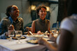© bernardbodo - Friends enjoying dinner together at restaurant, laughing and talking