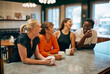 © Flamingo Images - Group of diverse friends laughing and enjoying coffee at a cozy cafe, while they are on break from their work.