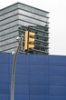 © yaqui_villegas - A solitary traffic light standing in front of a high-rise building, showcasing urban contrast and geometry.