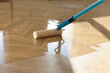 © New Africa - Polishing parquet with roller and varnish indoors, closeup