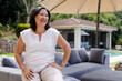 © Wavebreak Media - Smiling senior woman relaxing on outdoor sofa in garden near swimming pool, copy space