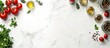 © yong - Flat lay of a white marble kitchen counter with food ingredients like tomatoes, herbs, and spices on the sides.