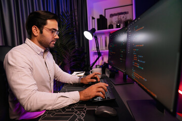 Working smart IT developer analyzing data software development on two pc screen, creating application program updated version online website page system online at neon light cyber office. Surmise.