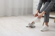 © New Africa - Woman changing shoes in armchair indoors, closeup. Space for text