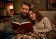 © Irina - Loving couple in the living room spends the evening reading a book, enjoying peace, coziness, and each other.