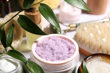 Wall Mural - different body care products and branches with leaves on light table, closeup