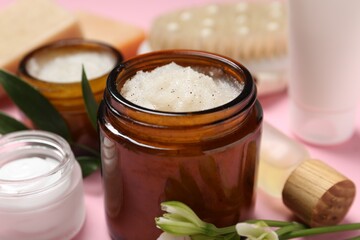 Wall Mural - body care products, flowers and leaves on pink background, closeup