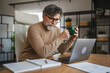 © Miljan Živković - mature senior man relax from work and drink coffee at home office