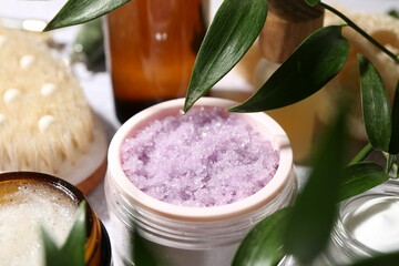 Wall Mural - different body care products and branches with leaves on light table, closeup