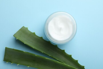 Wall Mural - cream and aloe leaves on light blue background, flat lay