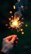 © Pawarit - Sparkler's warm glow illuminates a delicate hand, fire, female