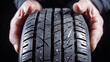 © Akash Tholiya - Close-up of mechanic hands holding a new car tire in an auto shop dedicated to tire replacement for various seasons