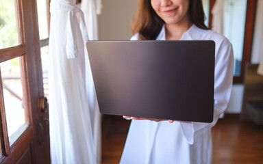 Wall Mural - closeup of a woman holding and working on laptop computer at home