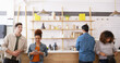 © peopleimages.com - Coffee shop, group and people waiting at counter with smartphone, small business or hospitality. Relax, customer or friends at trendy cafe for morning drinks, lunch break or online review for service