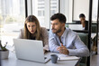© fizkes - Two colleagues working together, reviewing information, analyzing data, learning new platform engaged in professional task, researching, preparing for presentation using laptop met in modern coworking