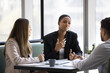 © fizkes - African and European colleagues negotiating, lead formal discussion about business proposal, deal, or project, share point of view, explaining solution, provide information during meeting in office