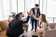 © fizkes - Four multinational teammates gathered together in modern coworking space giving high five, gesture of unity and teamwork, celebrating joint achievement, closing deal, completing project successfully