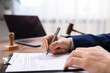 © New Africa - Notary signing document at table in office, closeup
