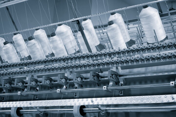 Poster - A machine is weaving a fabric with many threads. The machine is in a factory. Concept of industry and production